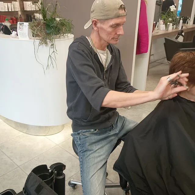 Friseur schneidet Kundin die Haare