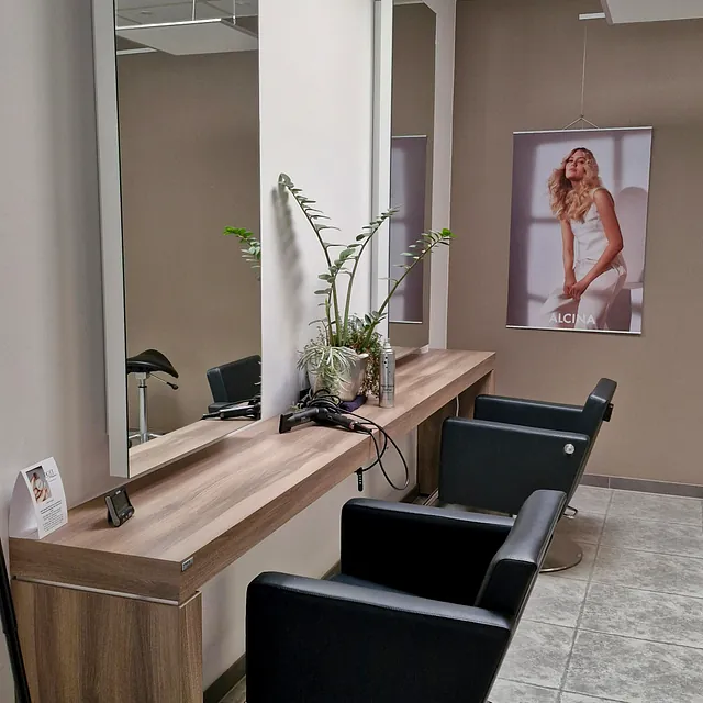 Friseursalon mit eleganten Stühlen und Spiegeln in der Ecke, einladend für Kunden.