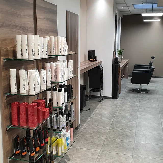 Ein Friseursalon mit Regalen voller Haarprodukte in verschiedenen Farben und Verpackungen. 